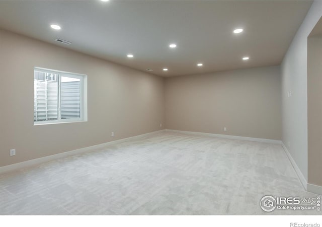 empty room featuring light carpet, visible vents, recessed lighting, and baseboards