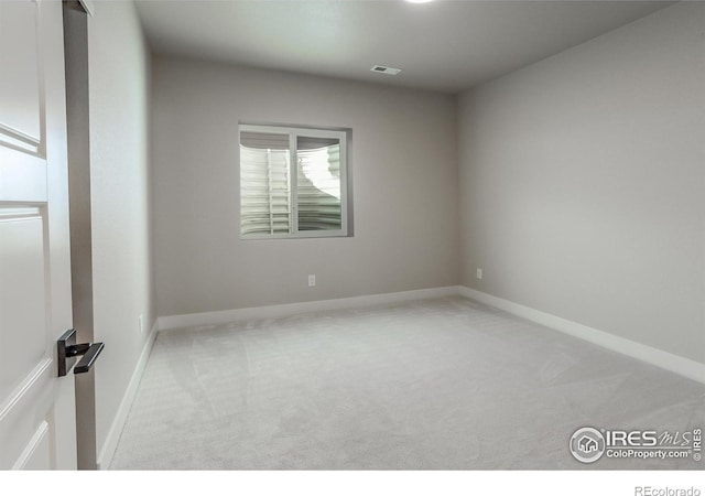 carpeted empty room with visible vents and baseboards