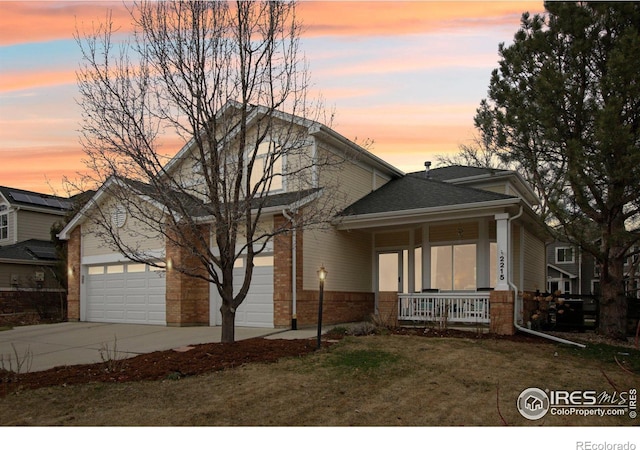 view of front of house with brick siding, a shingled roof, a porch, a garage, and driveway