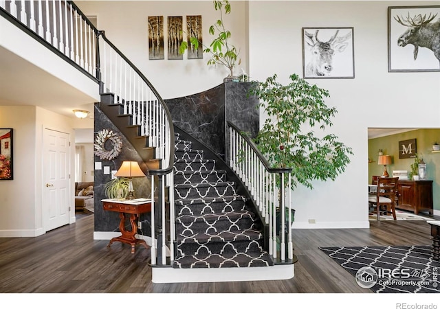 12023 Coal Creek Heights Dr, Golden, CO 80403 - stairs featuring baseboards, a towering ceiling, and wood finished floors