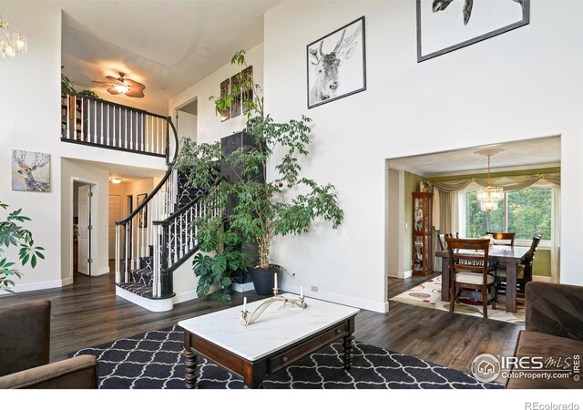 12023 Coal Creek Heights Dr, Golden, CO 80403 - living area with baseboards, wood finished floors, a towering ceiling, and an inviting chandelier