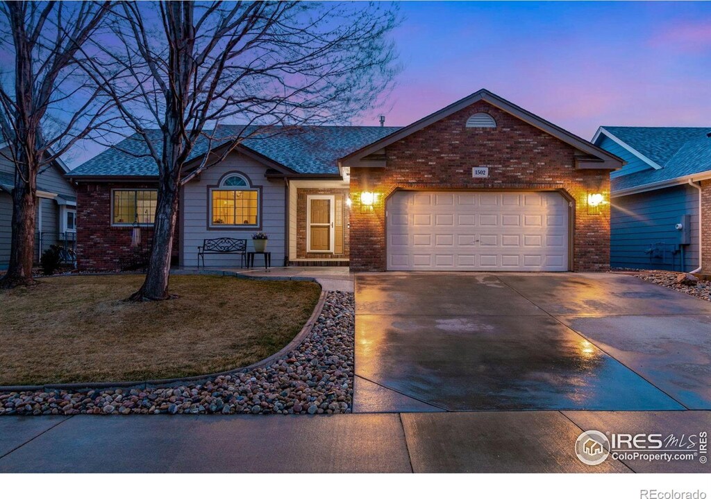 ranch-style home featuring brick siding, a front lawn, concrete driveway, and a garage