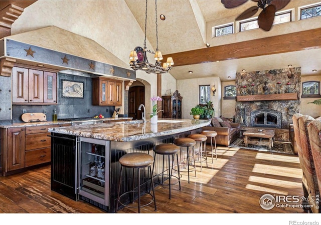 kitchen featuring wine cooler, arched walkways, a high ceiling, and dark wood finished floors