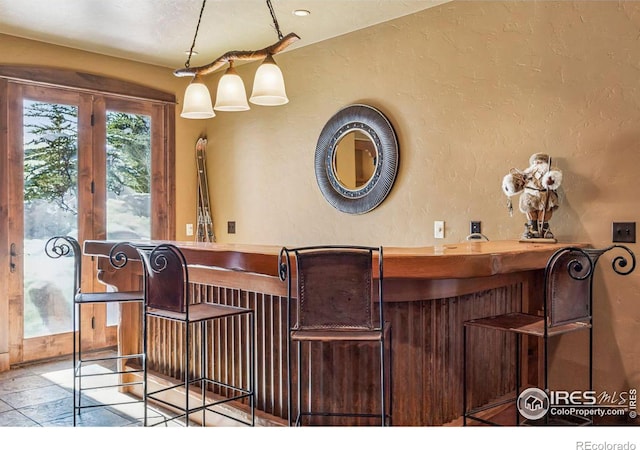 bar featuring a bar and a textured wall