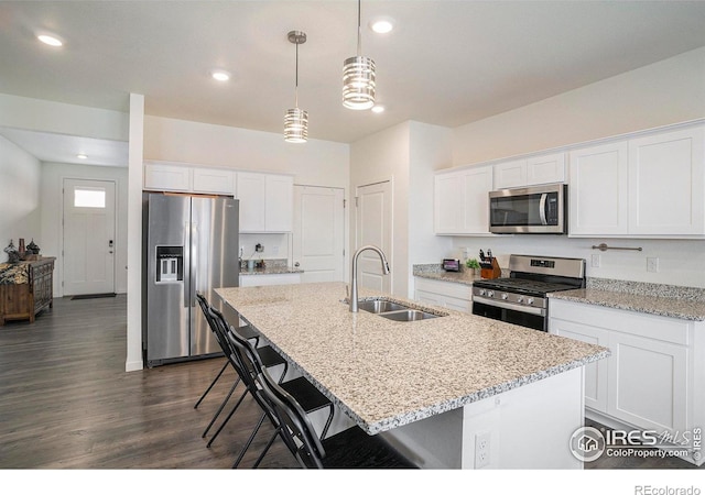 254 Ptarmigan Ln, Johnstown, CO 80534 - kitchen featuring stainless steel appliances, a kitchen island with sink, white cabinets, dark wood-style flooring, and recessed lighting