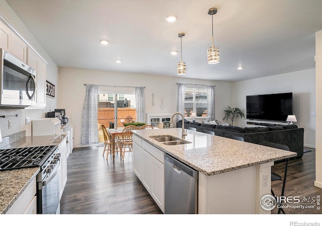 254 Ptarmigan Ln, Johnstown, CO 80534 - kitchen with appliances with stainless steel finishes, healthy amount of natural light, dark wood-type flooring, white cabinetry, and recessed lighting