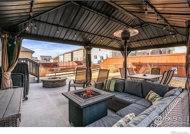 254 Ptarmigan Ln, Johnstown, CO 80534 - fenced backyard with an outdoor living space with a fire pit, a patio, outdoor dining space, and a gazebo