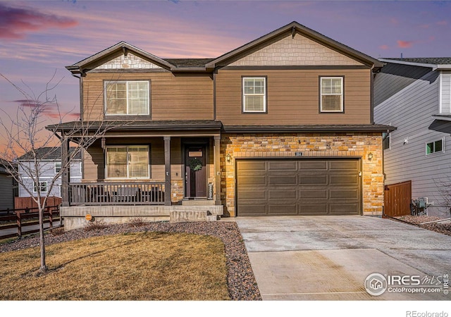 254 Ptarmigan Ln, Johnstown, CO 80534 - view of front facade featuring a porch, driveway, stone siding, and a garage