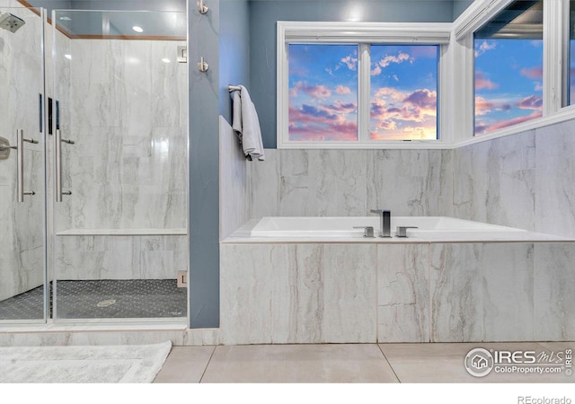 bathroom featuring a marble finish shower and a garden tub