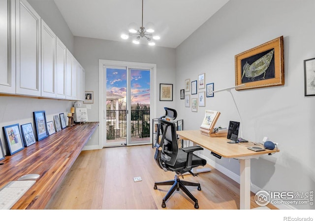home office with light wood finished floors, baseboards, and a chandelier