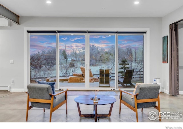 living room featuring recessed lighting, concrete floors, baseboards, and baseboard heating