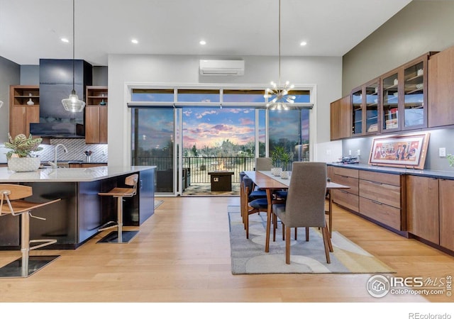 dining space with a wall mounted air conditioner, light wood-style floors, recessed lighting, and a chandelier