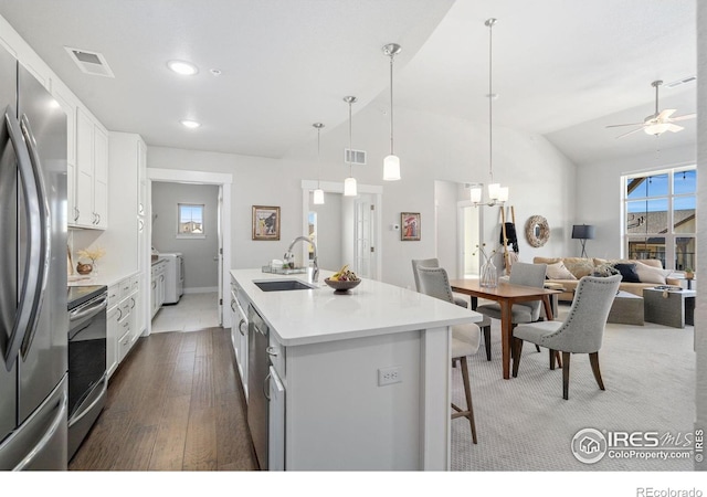 kitchen with washing machine and dryer, visible vents, stainless steel appliances, and a sink