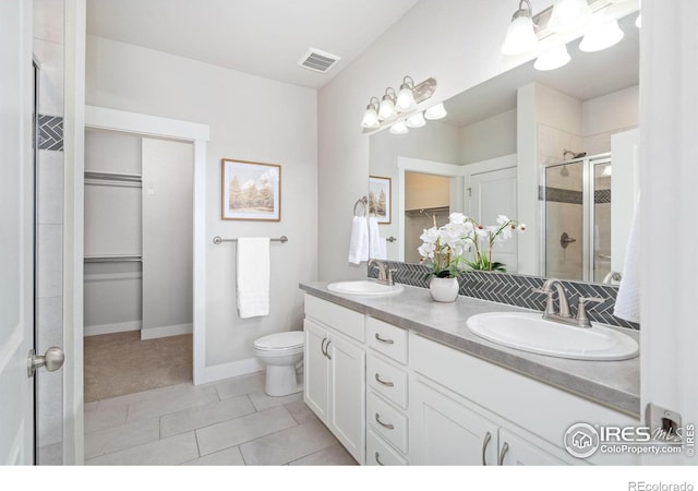 full bath with a sink, visible vents, a stall shower, and double vanity