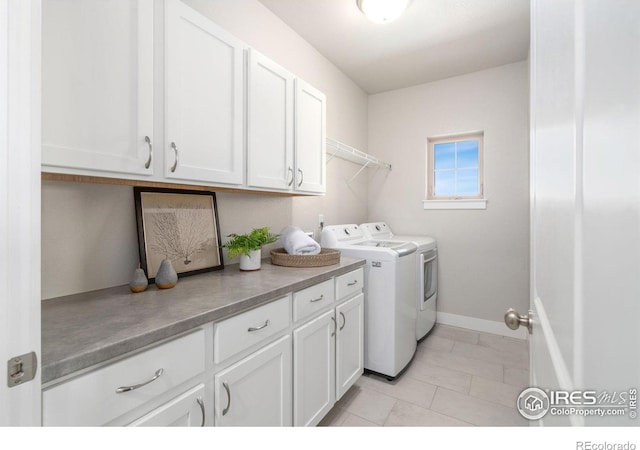 laundry room with washing machine and clothes dryer, cabinet space, and baseboards