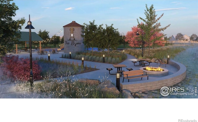 view of property's community with a patio area and a fire pit
