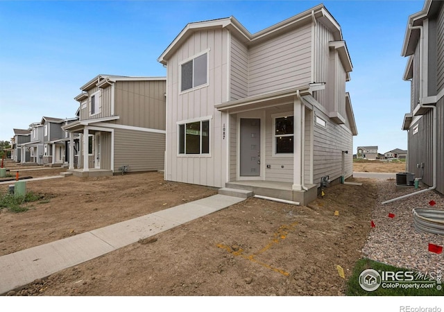 view of front facade featuring central AC unit and board and batten siding