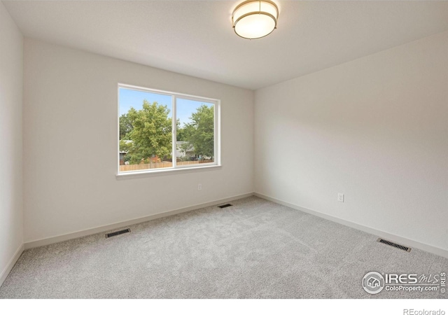 empty room with visible vents, carpet flooring, and baseboards