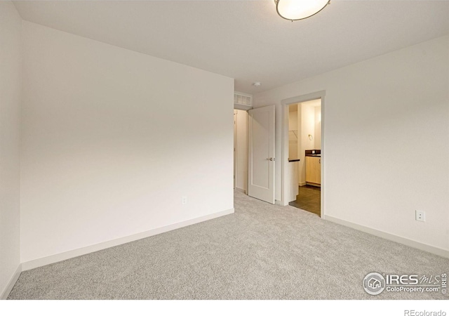 spare room with baseboards, carpet floors, and visible vents