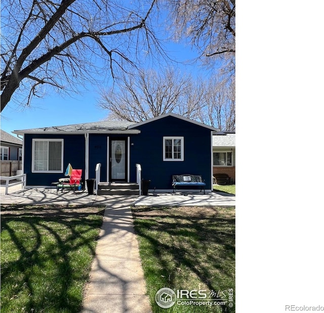 view of front of house with a front lawn and fence
