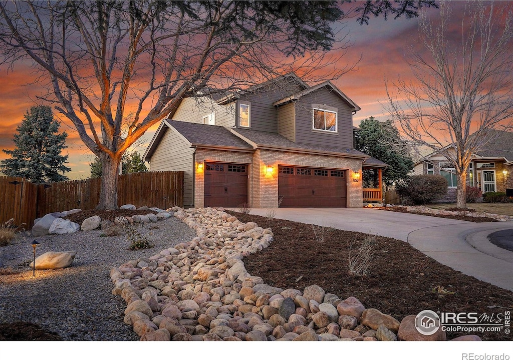 view of front of property featuring a garage, fence, brick siding, an attached garage, and driveway