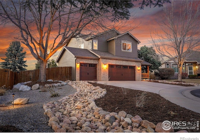 view of front of property featuring a garage, fence, brick siding, an attached garage, and driveway