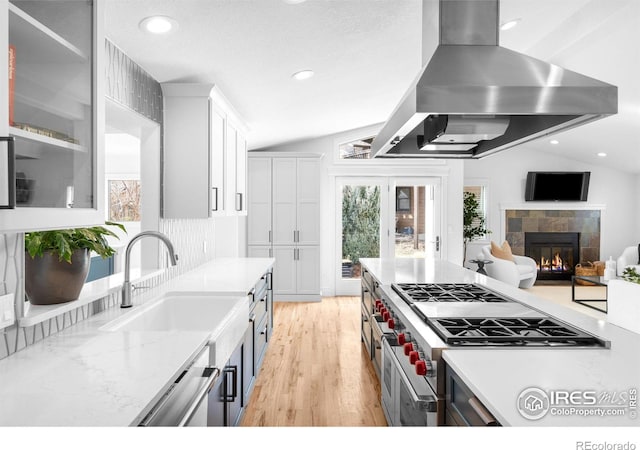 3380 Longwood Ave, Boulder, CO 80305 - kitchen featuring stovetop, light wood-style floors, white cabinets, wall chimney range hood, and vaulted ceiling