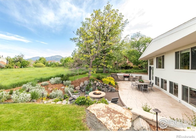 3380 Longwood Ave, Boulder, CO 80305 - view of green lawn featuring an outdoor fire pit, a mountain view, and a patio