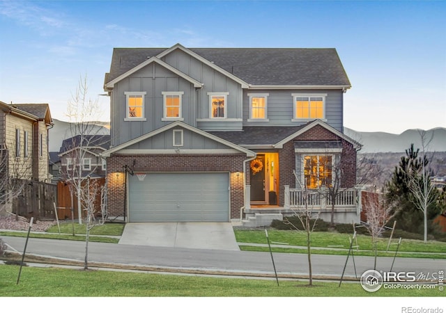 view of front facade with a garage, brick siding, board and batten siding, and concrete driveway
