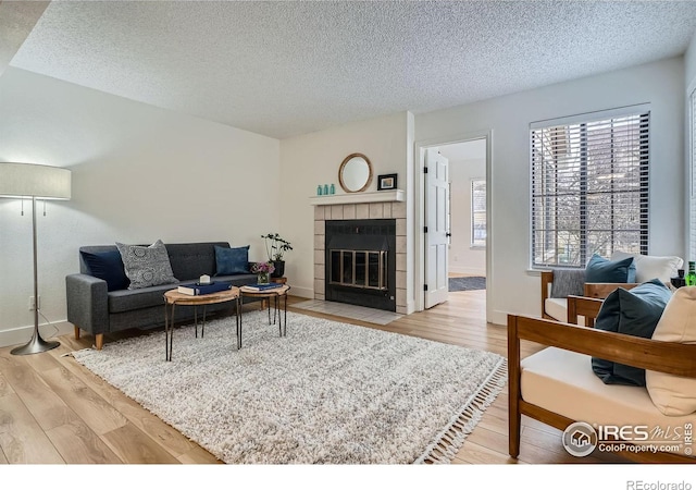 4799 White Rock Cir Unit D, Boulder, CO 80301 - living room featuring a textured ceiling, light wood-style flooring, and a tile fireplace