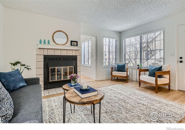4799 White Rock Cir Unit D, Boulder, CO 80301 - living room featuring wood finished floors, a textured ceiling, and a tiled fireplace