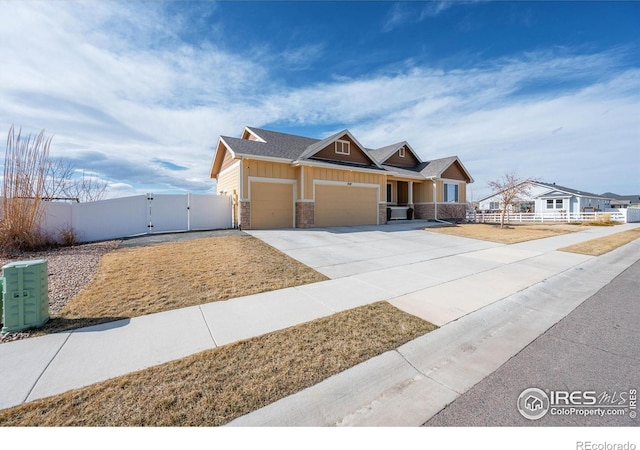 view of front of home with concrete driveway, fence, a garage, and a gate