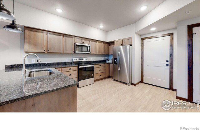 1734 Wildfire Rd Unit 204, Estes Park, CO 80517 - kitchen with appliances with stainless steel finishes, a sink, light wood-style floors, recessed lighting, and dark stone countertops