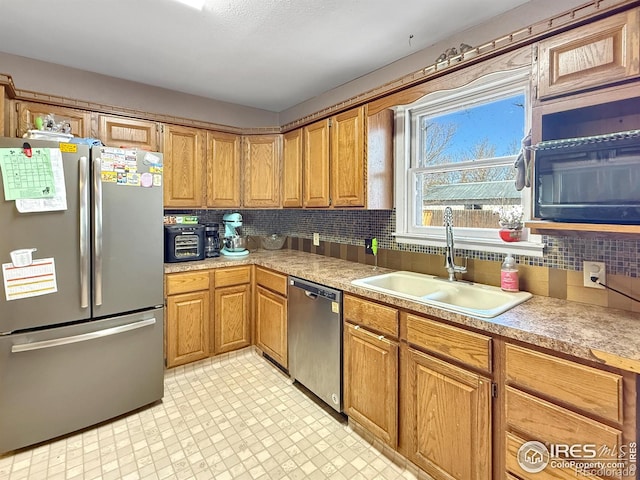 105 N Logan Ave, Haxtun, CO 80731 - kitchen with stainless steel appliances, backsplash, light countertops, light floors, and brown cabinets