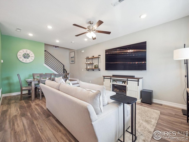living area featuring baseboards, wood finished floors, ceiling fan, and recessed lighting
