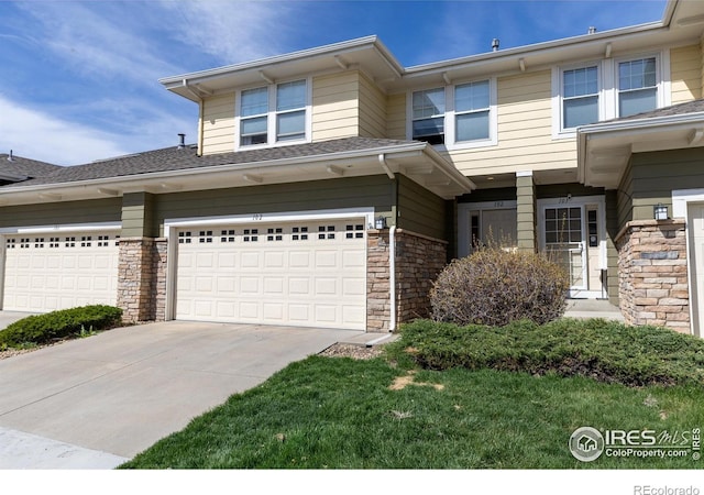view of front of house featuring a garage, driveway, and stone siding