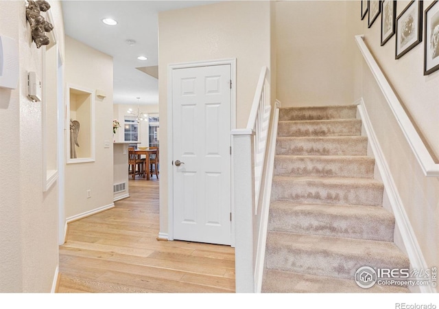 stairway featuring recessed lighting, visible vents, and wood finished floors