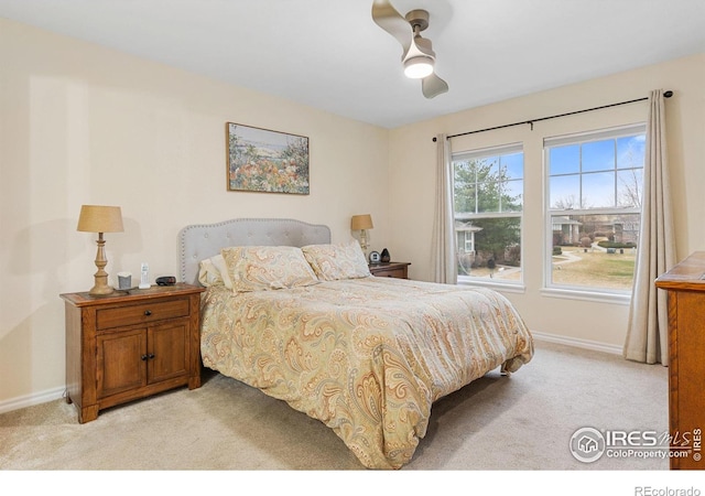 bedroom with light colored carpet, baseboards, and ceiling fan