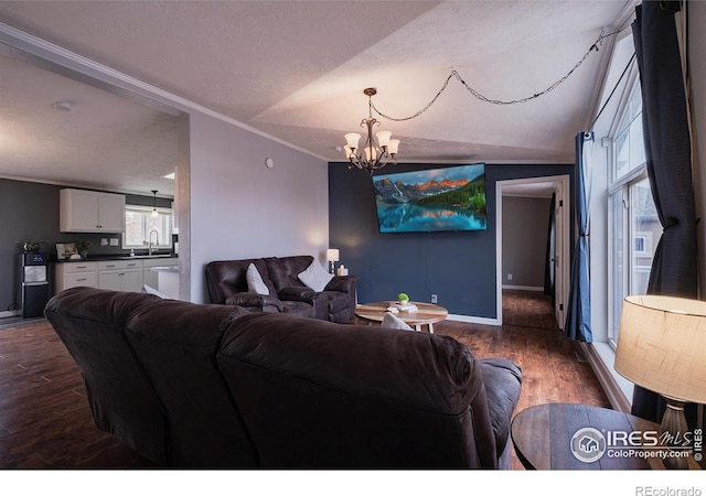 603 Lark Ln, Sterling, CO 80751 - living room featuring a chandelier, crown molding, dark wood-style flooring, baseboards, and a textured ceiling