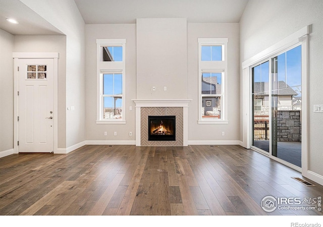 4300 Ardglass Ln, Timnath, CO 80547 - unfurnished living room with a tile fireplace, wood-type flooring, and baseboards