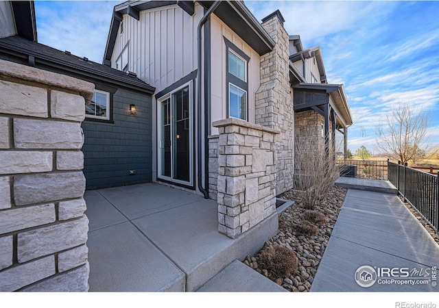 4300 Ardglass Ln, Timnath, CO 80547 - view of home's exterior with stone siding, board and batten siding, and a patio area