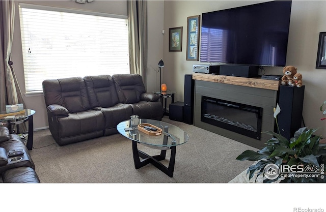 carpeted living area with a glass covered fireplace