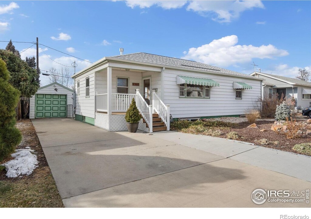 1607 Jackson Ave, Loveland, CO 80538 - view of front facade with a garage, covered porch, driveway, and an outdoor structure
