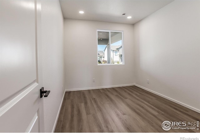unfurnished room featuring recessed lighting, wood finished floors, and baseboards