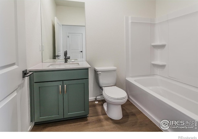 bathroom featuring toilet, vanity, wood finished floors, and baseboards
