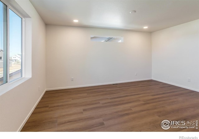 empty room featuring recessed lighting, wood finished floors, and baseboards