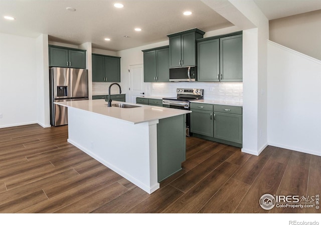 kitchen with stainless steel appliances, a sink, recessed lighting, and dark wood finished floors