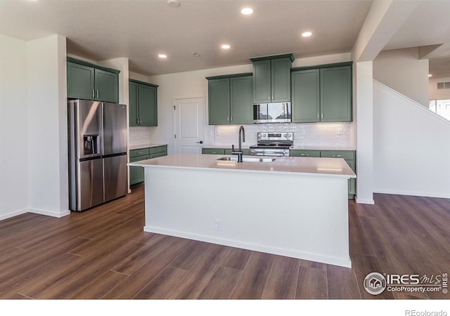 kitchen featuring dark wood finished floors, green cabinetry, stainless steel appliances, and a sink