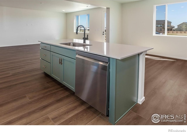 kitchen featuring dark wood-style floors, a sink, dishwasher, light countertops, and an island with sink