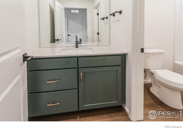 bathroom with wood finished floors, vanity, and toilet